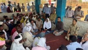 चुटका गांव में कलेक्टर राहुल नामदेव धोटे और एसपी रजत सकलेचा ग्रामीणों के साथ जमीन पर बैठकर परमाणु परियोजना को लेकर चर्चा करते हुए, आसपास बड़ी संख्या में ग्रामीण उपस्थित।